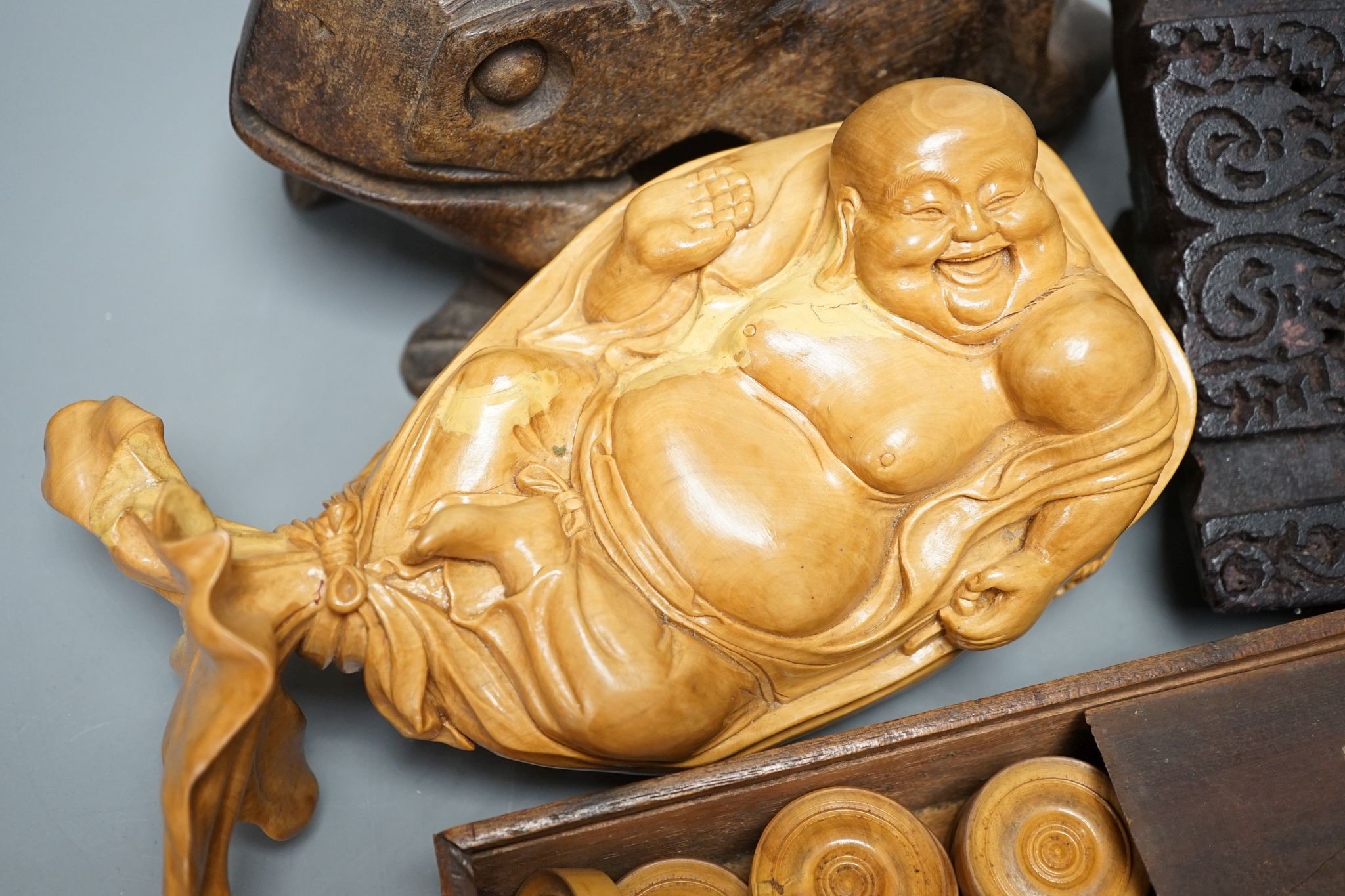 A Chinese carved wood frog, 22cm long, a carved Buddha, woodblock and a part-set of draughtsmen